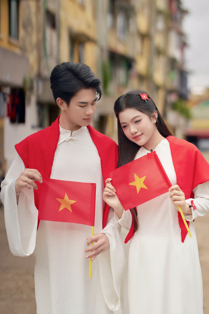 Cặp đôi áo dài trắng cầm cờ đỏ sao vàng